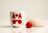 White ceramic mug with red elf illustration and heart.