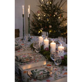 Table setting with Ekelund Julefrojd table runner, candles, glassware, and Christmas tree in background.