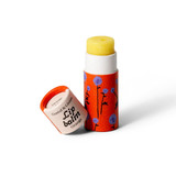 Orange lip balm with blue floral pattern, cap off.