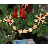 Christmas tree garland with straw snowflakes and ornaments; red and green accents.