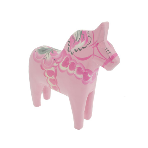 A pink Nils Olsson wooden Dala horse figurine decorated with white and grey traditional patterns, shown from a front-right