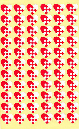 Red and white woven heart stickers on a yellow background