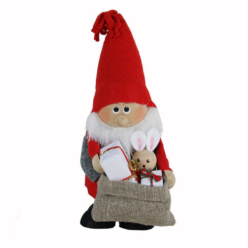 Nordic tomte figure in red hat with white beard, holding a burlap sack of gifts and a rabbit.
