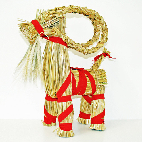 A traditional Swedish straw goat, the Julbock, tied with bright red ribbon.