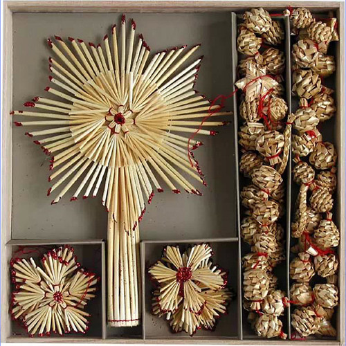 Straw star tree topper and ornaments in a box; natural wheat straw, red accents.