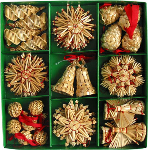 Assortment of straw Christmas ornaments in a green box. Natural straw, red accents. Various shapes: stars, bells, cones.