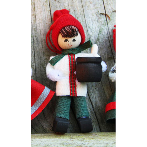 Wooden Tomte boy ornament wearing a red knit hat, white tunic with Nordic ribbon, and holding a black porridge pot.