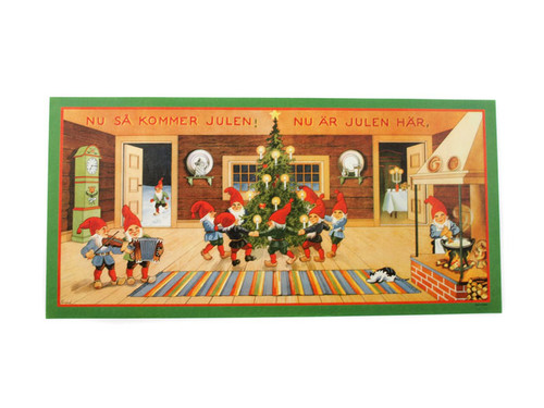 A 14"x 29" Swedish Christmas poster showing tomtes dancing around a lit tree in a rustic interior.