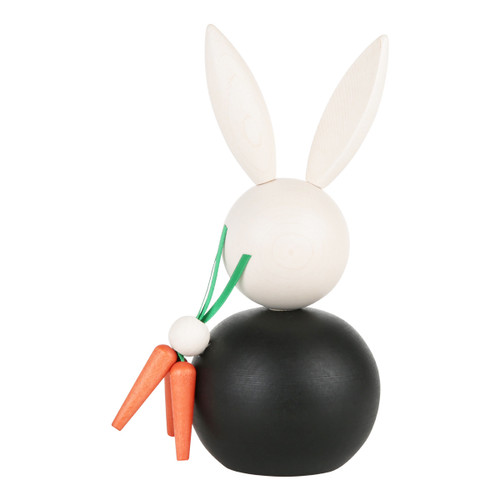 Handmade wooden Aarikka Pupujussi bunny figurine in black, holding orange carrots.