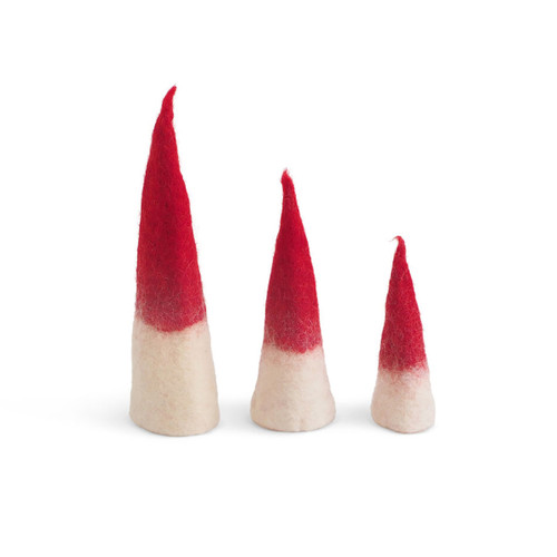 Three red and white felted wool pixie figurines in descending heights on a white background.