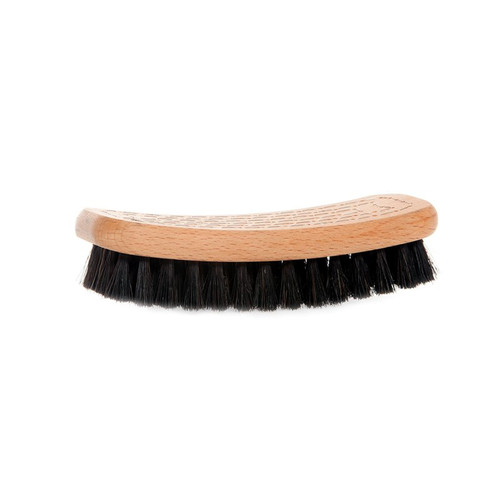 A curved wooden shoe brush with dark, dense horsehair bristles, viewed from the side on a white background.