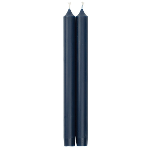 Two tall, dark blue taper candles with pointed crown tops standing upright side by side.