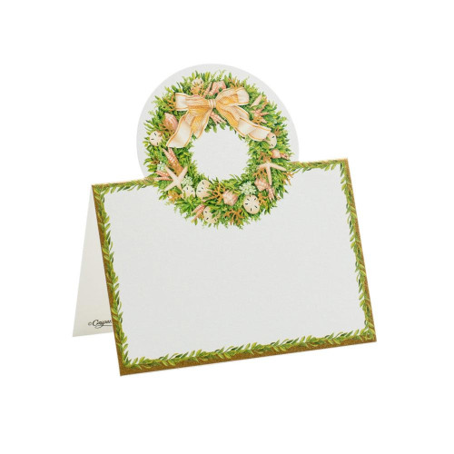 Folded place card with a seashell wreath and gold ribbon, bordered by greenery.