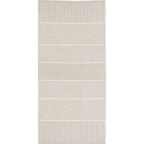 Sand-colored rug with striped and patterned sections; cotton and vinyl blend.