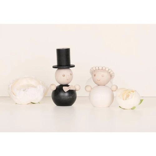 Aarikka wooden groom figurine in black and natural maple with a top hat, flanked by a bride figurine and white flowers.