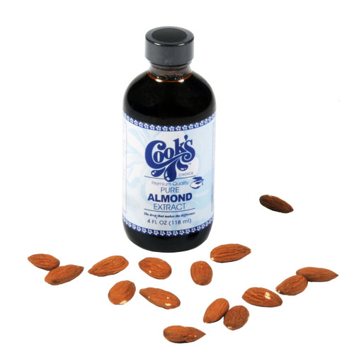 Bottle of Cooks Pure Almond Extract with scattered almonds on a white background.