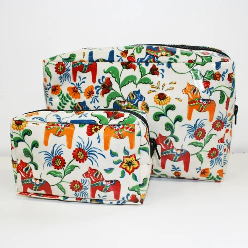 Two Arvidssons cream canvas makeup bags with a colorful Dala horse and floral Kurbits pattern.