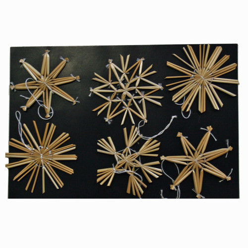 Six natural straw star and snowflake ornaments on black background
