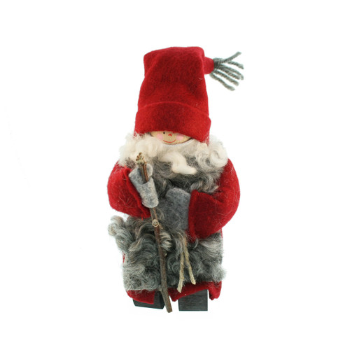 Swallings Tomte figure in a red hat, grey sheepskin coat, and walking stick.