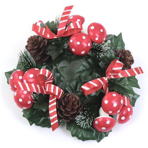 Red and white polka dot mushrooms, pine cones, and green leaves on a Christmas wreath.