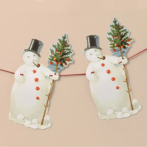 Two paper snowman cutout ornaments on a red string, wearing black top hats and holding decorated trees.