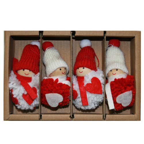 Four fluffy yarn tomte ornaments in a box, red and white outfits, Scandinavian Christmas decorations.
