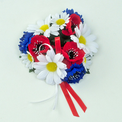 Red, white, and blue artificial flower candle ring with poppies, daisies, and ribbons
