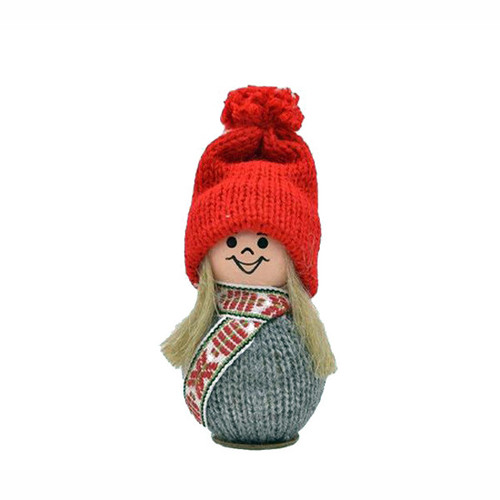 A small figurine of a tomte girl with blonde hair, a red knit hat, patterned scarf, and grey sweater.