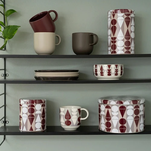 Ceramic breakfast bowl with a red and white geometric elf pattern on shelves.