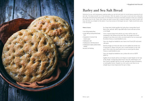 Two round loaves of barley and sea salt bread, golden brown, sprinkled with sea salt, in a bowl.