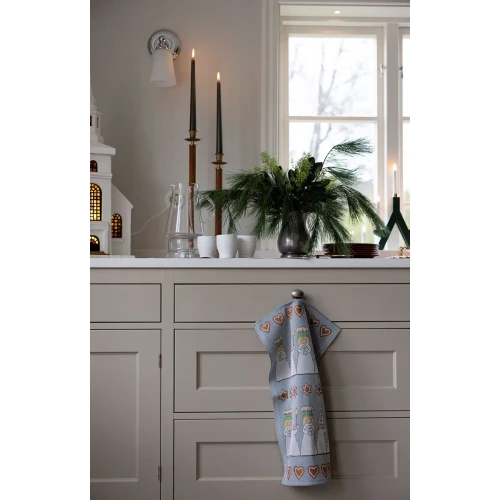 A blue Ekelund Luciamorgon organic cotton tea towel hanging from a kitchen drawer knob.