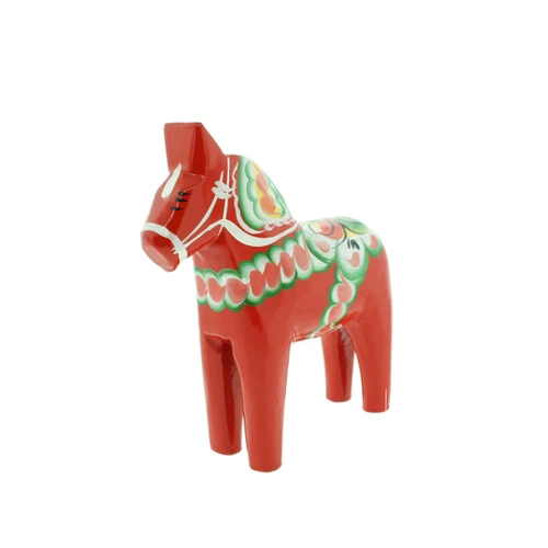 Handcrafted red wooden Dala horse with green and white kurbits folk art pattern.