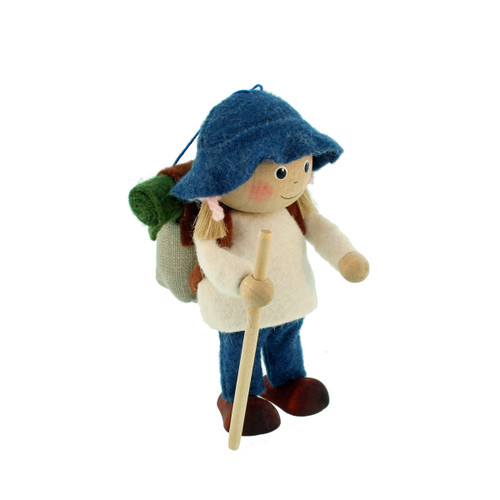 Wooden and felt hiker girl ornament wearing a blue hat, white sweater, and blue pants, carrying a backpack and holding a