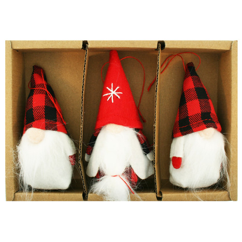 Three hanging gnome ornaments in a cardboard box, featuring white beards and red-and-black plaid felt hats.