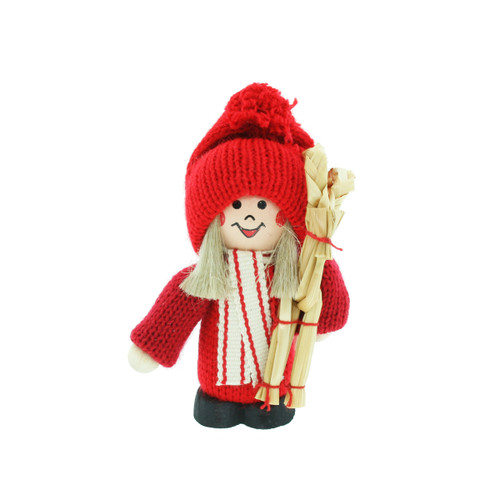 A Swedish tomte figurine in red knit hat, sweater, and scarf, holding a straw goat.