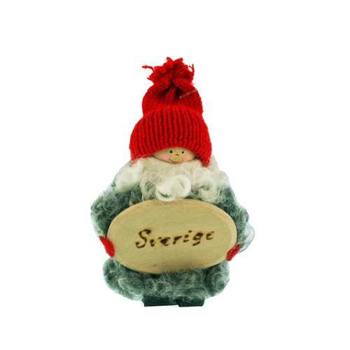 Handmade Swedish tomte figure with a red knit hat, white sheepskin beard, and wood sign reading "Sverige.