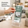 Hand removing a Home Interior RIP Card from a clear countertop display filled with matching cards.
