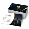Stack of glossy business cards with navy and gold branding beside a card featuring contact details and a New York skyline