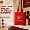 Red custom tote bag with a Maison Rose logo displayed as reusable branded packaging in a retail boutique.