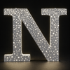 Illuminated front and side perforated stainless steel sign letters at night