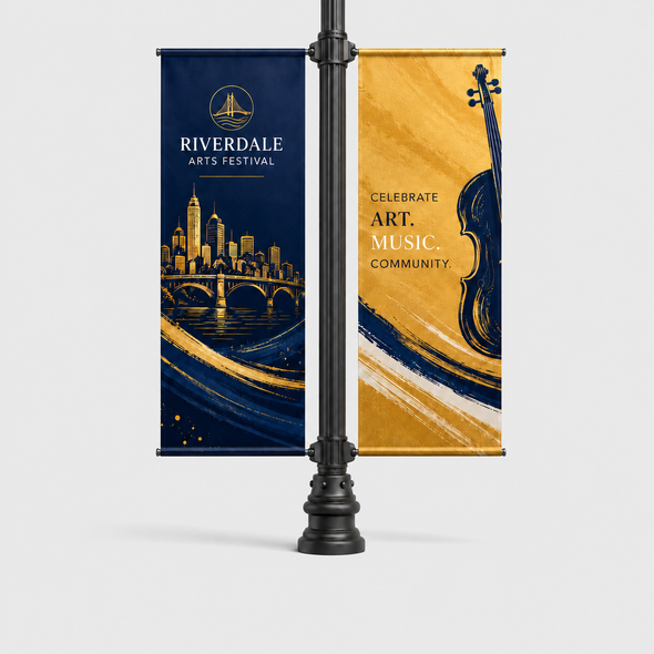 Two custom Riverdale Arts Festival pole banners in navy and gold displayed on opposite sides of a black lamp post.