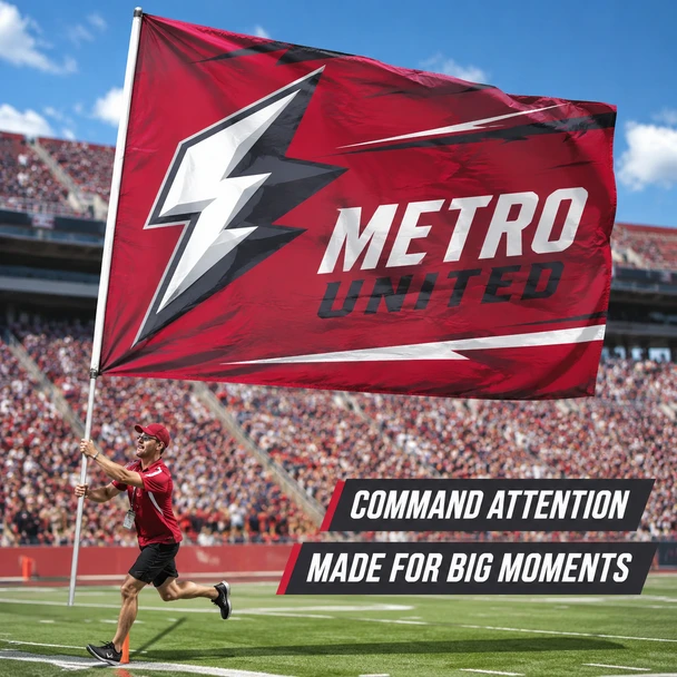 Person carrying a large red Metro United spirit flag across a crowded outdoor sports stadium.