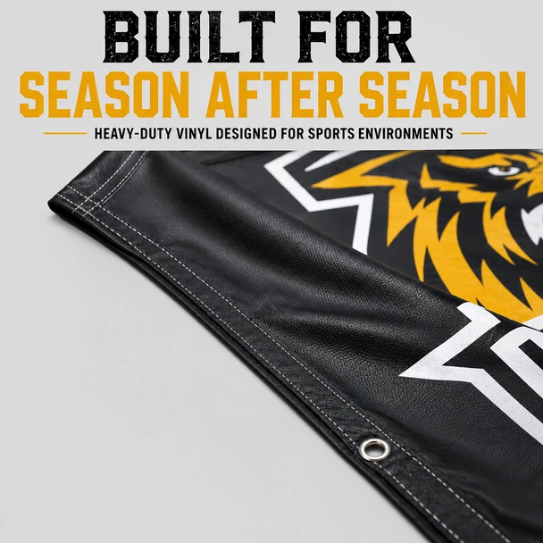 Close-up of a black vinyl breakaway banner edge with reinforced stitching and a metal grommet.