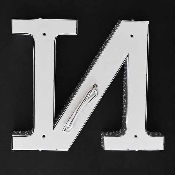Illuminated front and side perforated stainless steel sign letters at night