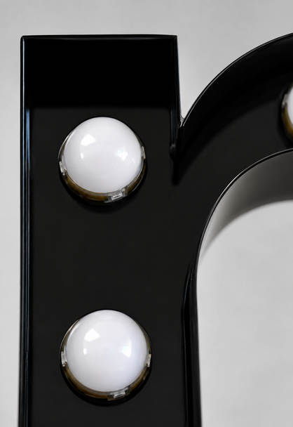 Close up of vintage style exposed frosted LED marquee globe bulbs on metal letter