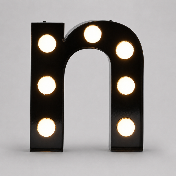 Warm glowing exposed bulb marquee channel letters illuminated on wall at night