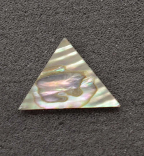 Green abalone (Mexican green abalone) triangle 25 x 25 x 27 x 1mm. Some uses include fretboard markers, musical instrument inlay, furniture inlay, marquetry and other general decorative inlay and jewellery applications. All pcs are A grade.