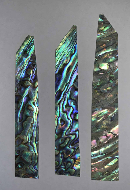 Paua shell inlay feathers consist of single piece solid shell face layer 0.5mm thick laminated to shell laminate backing size 17-20mm width x 85-100mm length  x .1.6mm total thickness  (including 1.1mm laminated sheet backing). Suitable for inlays, marquetry.