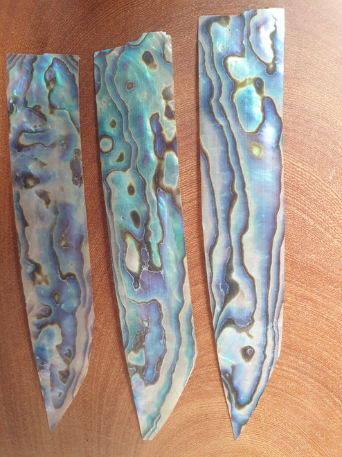 Paua shell feathers 25-30mm (1-1.2") width x 90-115mm (3.5-4.5") length x 0.15mm (0.006") thickness - thinly sliced solid shell pcs. Cut along the curved part of shell they can yield larger pcs then standard solid shell blanks. Ideal for shallow inlay, overlay, fishing lure manufacture and other decorative purposes.