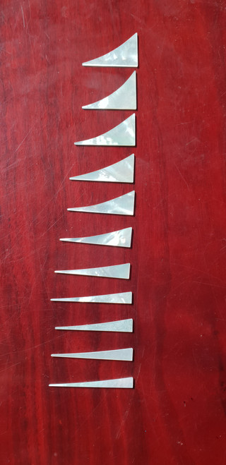 A set of 11pcs White MOP Shark fin inlays. Thickness 1.5mm. Flat and ready to be installed.